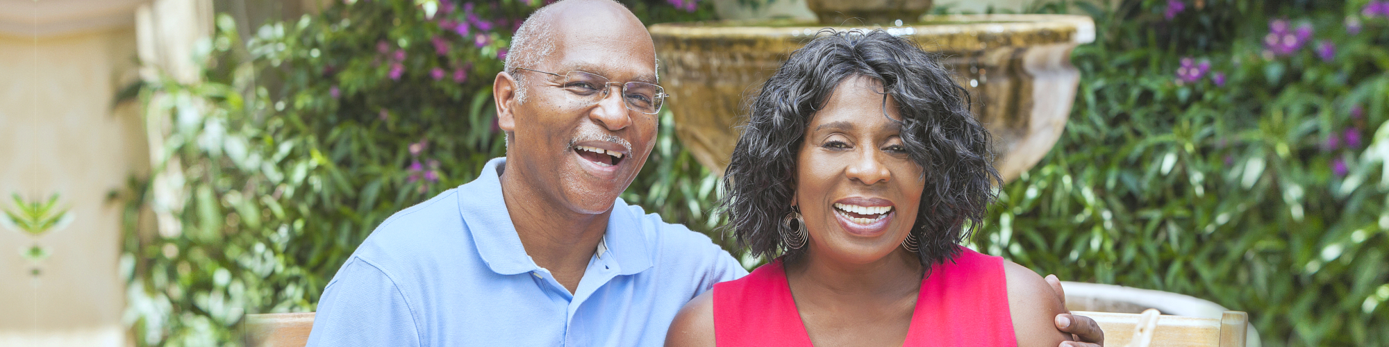 a happy elderly couple eating at a picnic table outside their home