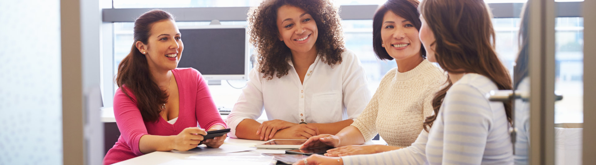 group of female colleagues talking in a meeting room